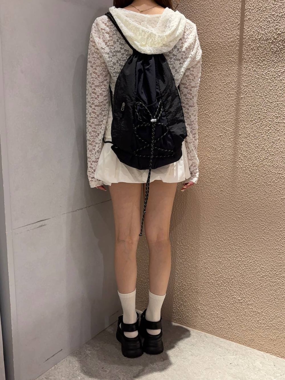 ホワイト系のTシャツ/カットソー、ブラック系のバックパック/リュック、ブラック系のサンダルを着用したレディースの夏コーディネートの3枚目の写真
