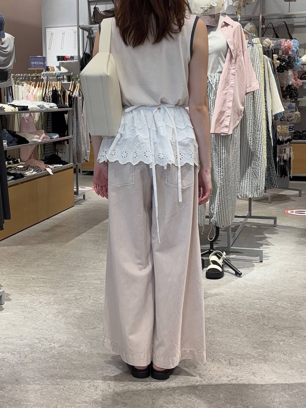 ピンク系のタンクトップ、ピンク系のデニムパンツ、ホワイト系のサンダルを着用したレディースの春コーディネートの2枚目の写真