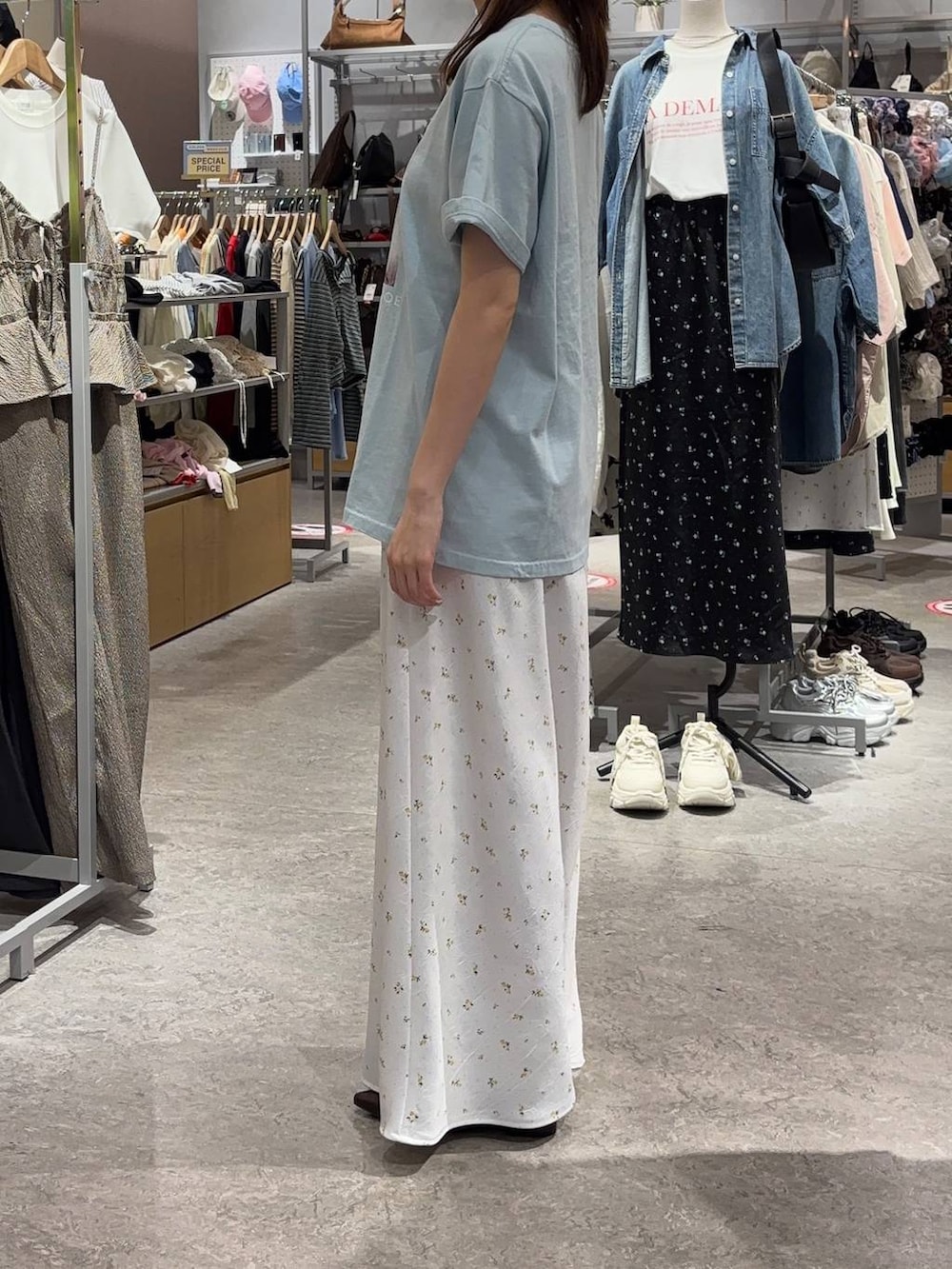 ホワイト系のスカート、ブラウン系のサンダル、ブルー系のTシャツ/カットソーを着用したレディースの春コーディネートの2枚目の写真