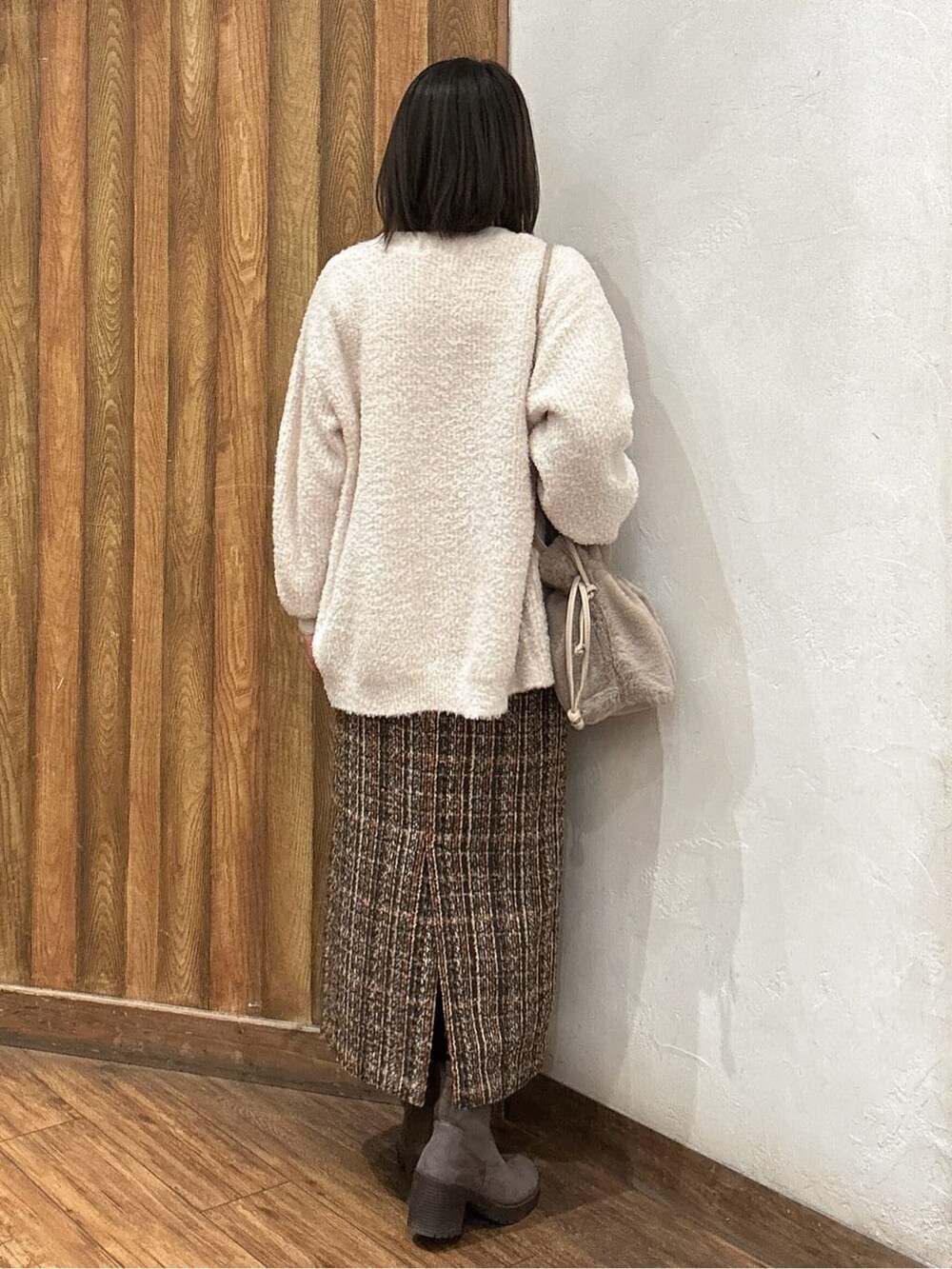ベージュ系のカーディガン/ボレロ、ブラウン系のスカート、ブラウン系のブーツを着用したレディースの冬コーディネートの3枚目の写真