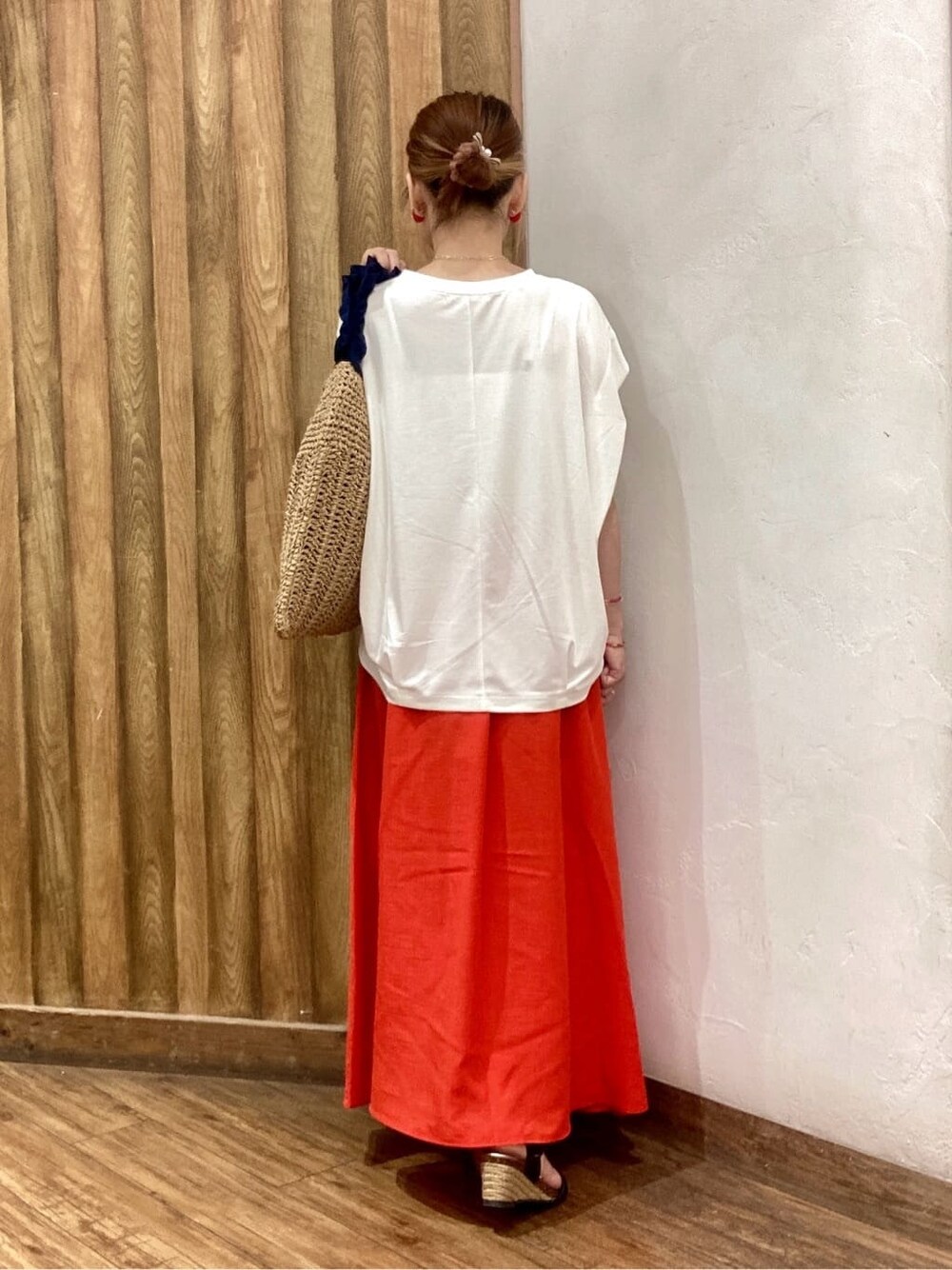 ホワイト系のTシャツ/カットソー、レッド系のスカート、ブラック系のサンダルを着用したレディースの夏コーディネートの3枚目の写真