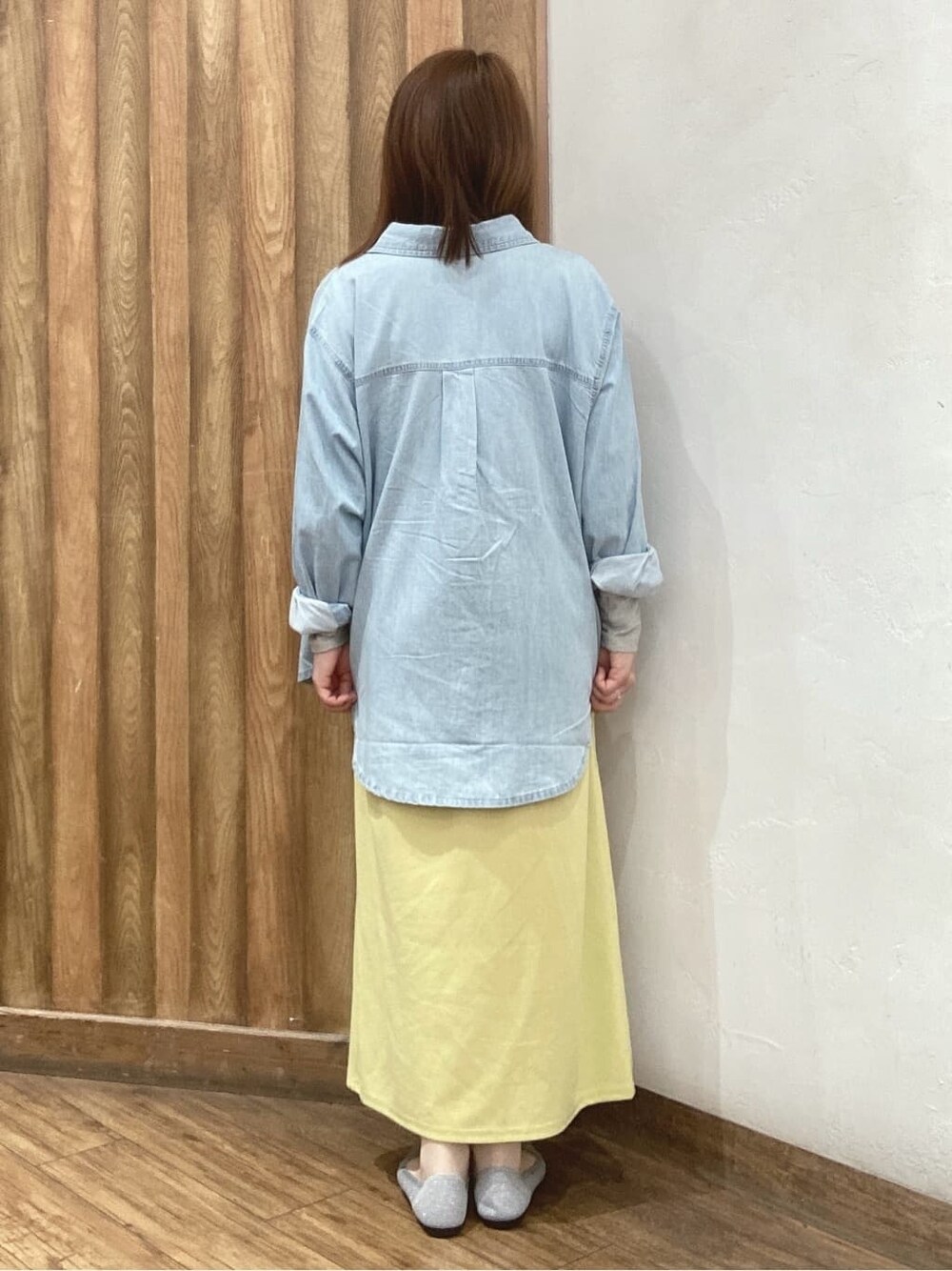 ブルー系のシャツ/ブラウス、グレー系のニット/セーター、イエロー系のスカートを着用したレディースの春コーディネートの3枚目の写真