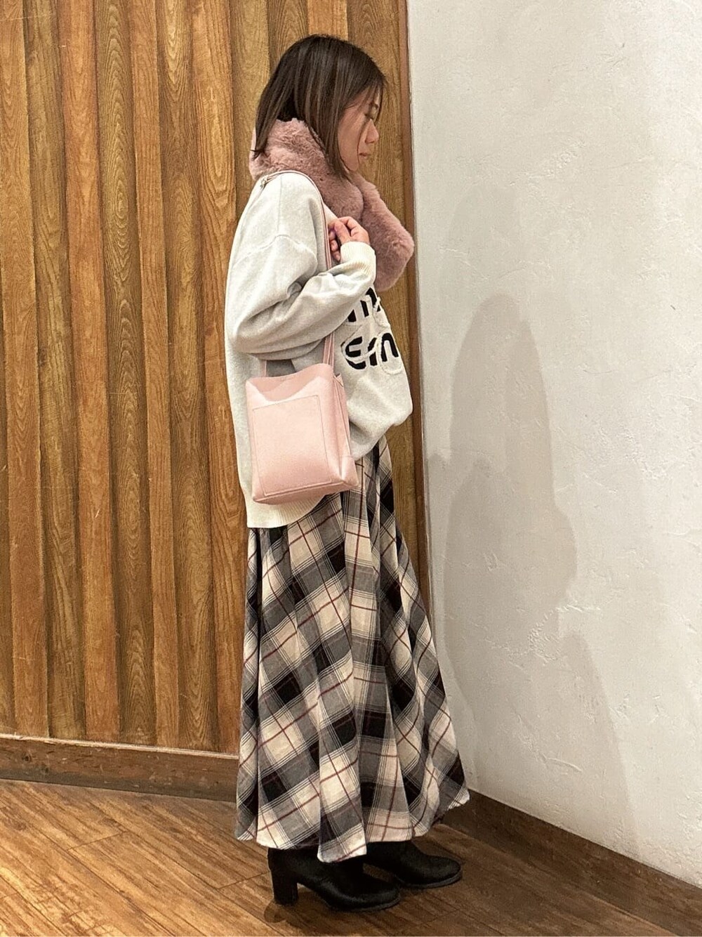 ホワイト系のニット/セーター、ベージュ系のスカート、ピンク系のショルダーバッグを着用したレディースの冬コーディネートの2枚目の写真