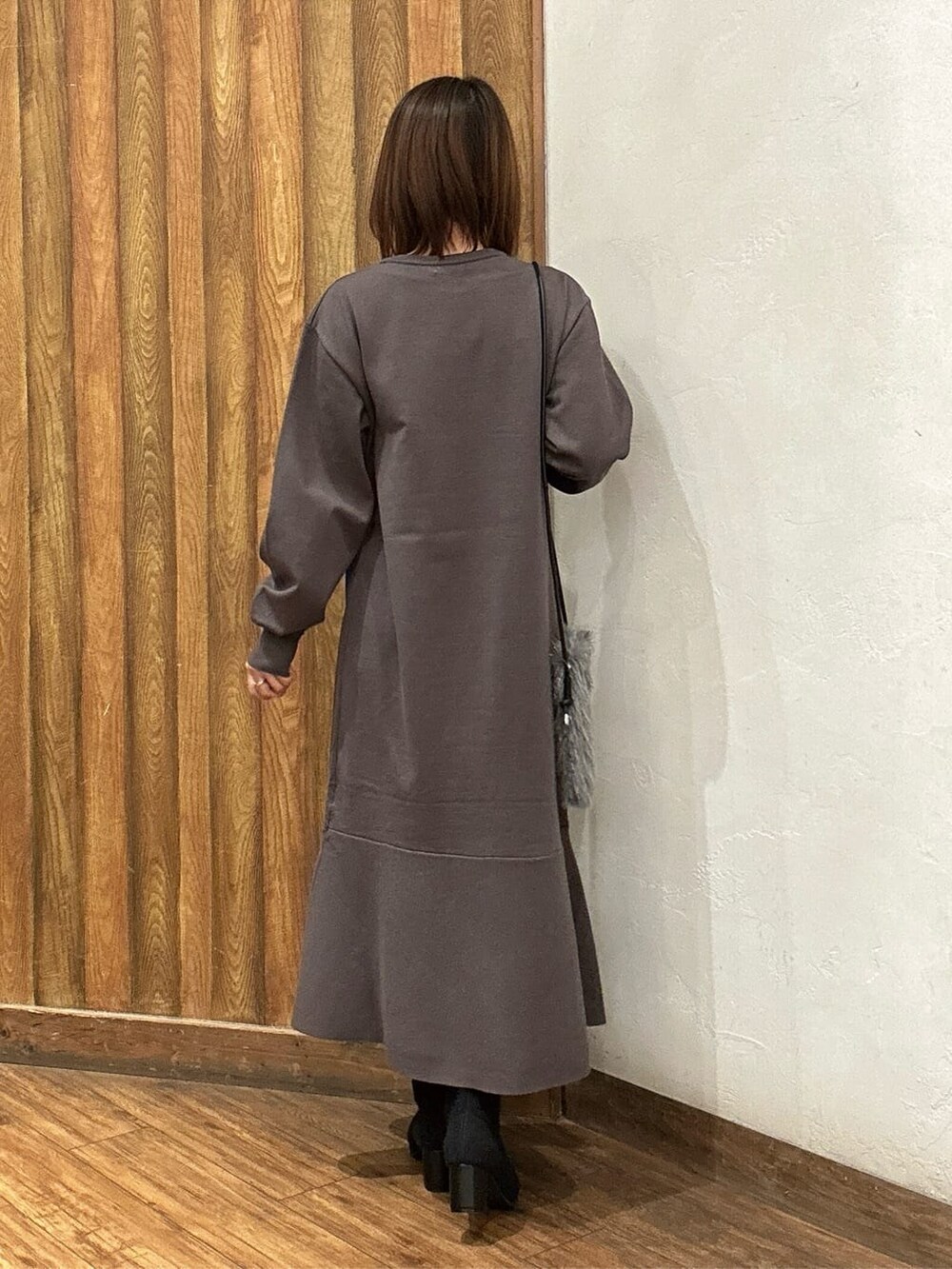 ベージュ系のダウンジャケット/コート、ブラウン系のワンピース、ブラック系のブーツを着用したレディースの秋コーディネートの6枚目の写真