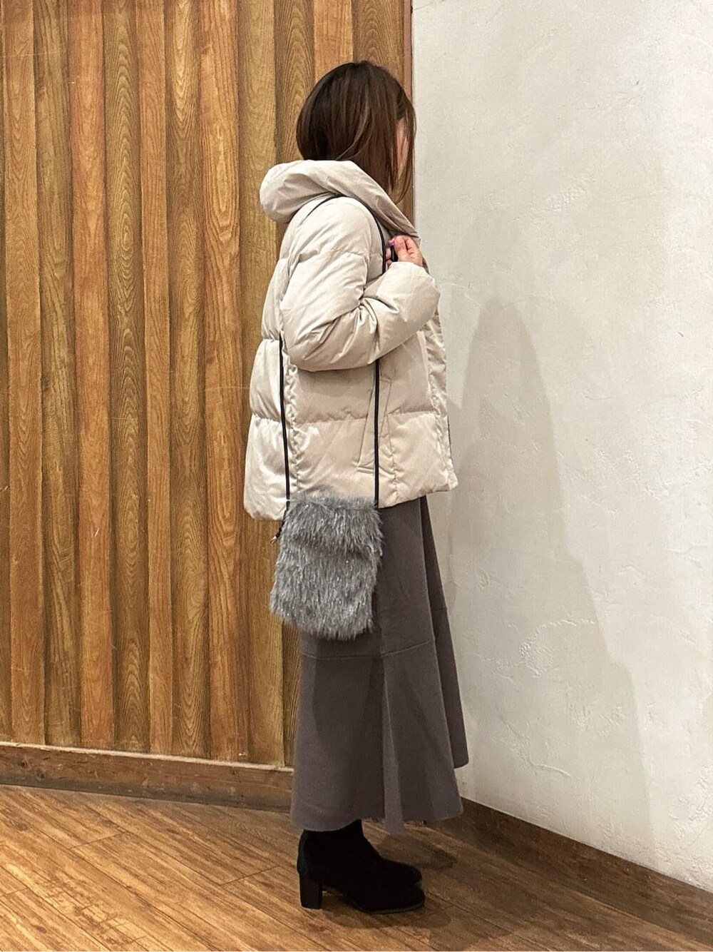 ベージュ系のダウンジャケット/コート、ブラウン系のワンピース、ブラック系のブーツを着用したレディースの秋コーディネートの2枚目の写真
