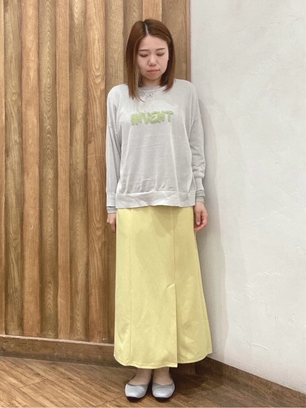 ブルー系のシャツ/ブラウス、グレー系のニット/セーター、イエロー系のスカートを着用したレディースの春コーディネートの4枚目の写真