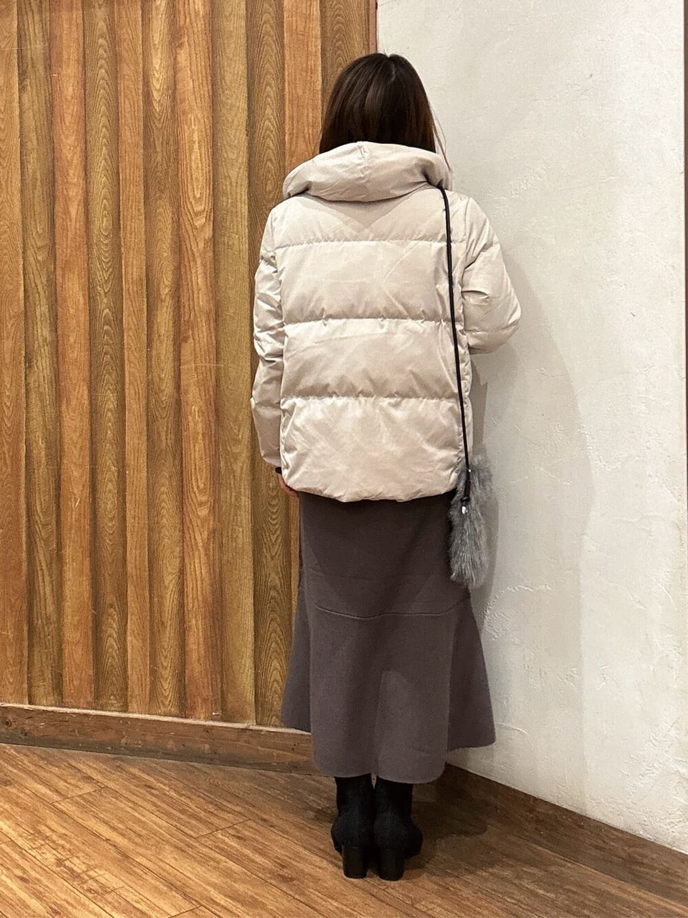 ベージュ系のダウンジャケット/コート、ブラウン系のワンピース、ブラック系のブーツを着用したレディースの秋コーディネートの3枚目の写真