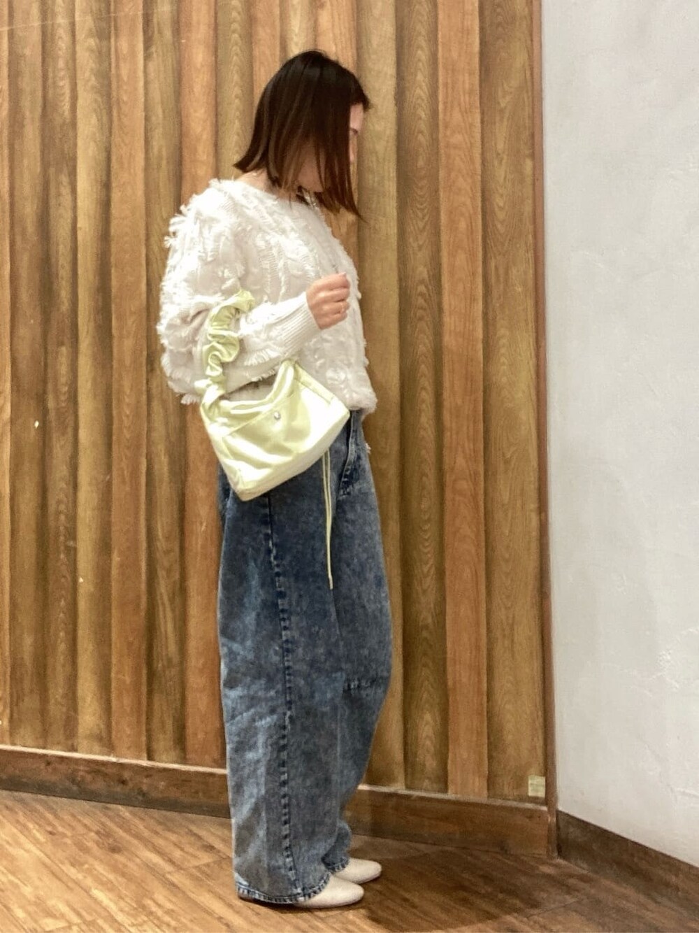 ホワイト系のニット/セーター、ブルー系のその他パンツ、イエロー系のショルダーバッグを着用したレディースの冬コーディネートの3枚目の写真