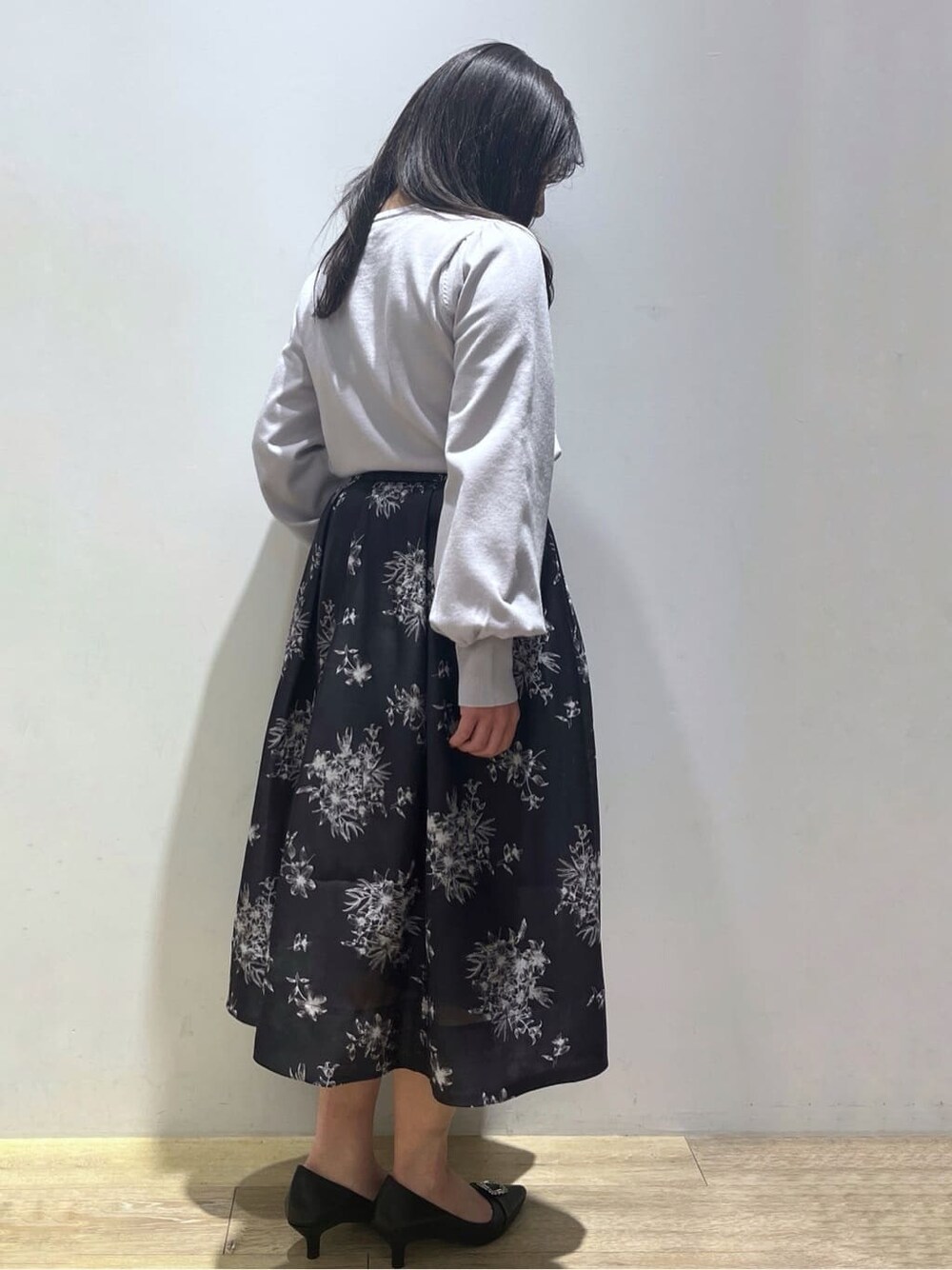 ブルー系のニット/セーター、ブルー系のスカート、ブラック系のショルダーバッグを着用したレディースの春コーディネートの4枚目の写真