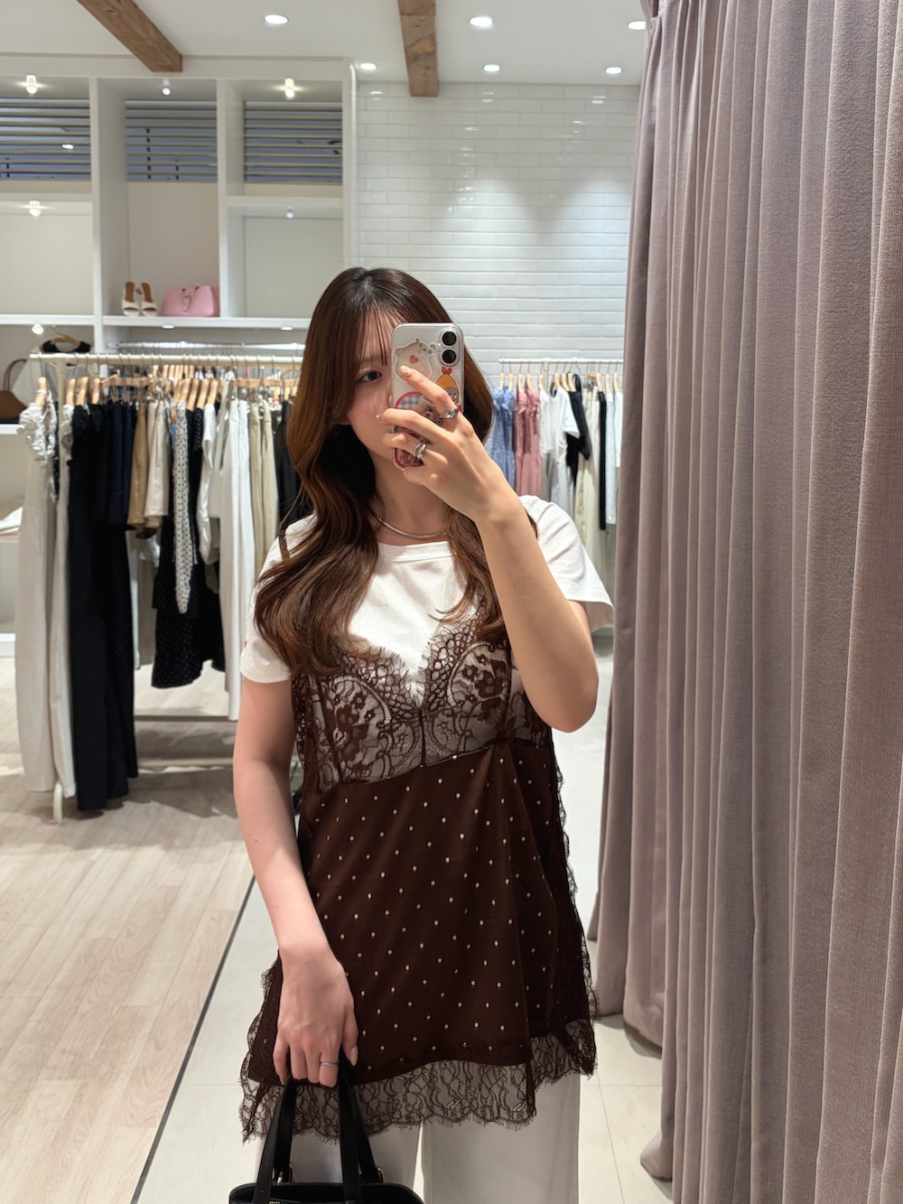 ブラウン系のキャミソール、ホワイト系のTシャツ/カットソー、ホワイト系のデニムパンツを着用したレディースの夏コーディネートの2枚目の写真
