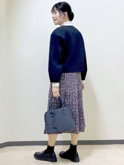 ブルー系のノーカラージャケット、ベージュ系のニット/セーター、ブルー系のスカートを着用したレディースの冬コーディネートの4枚目の写真
