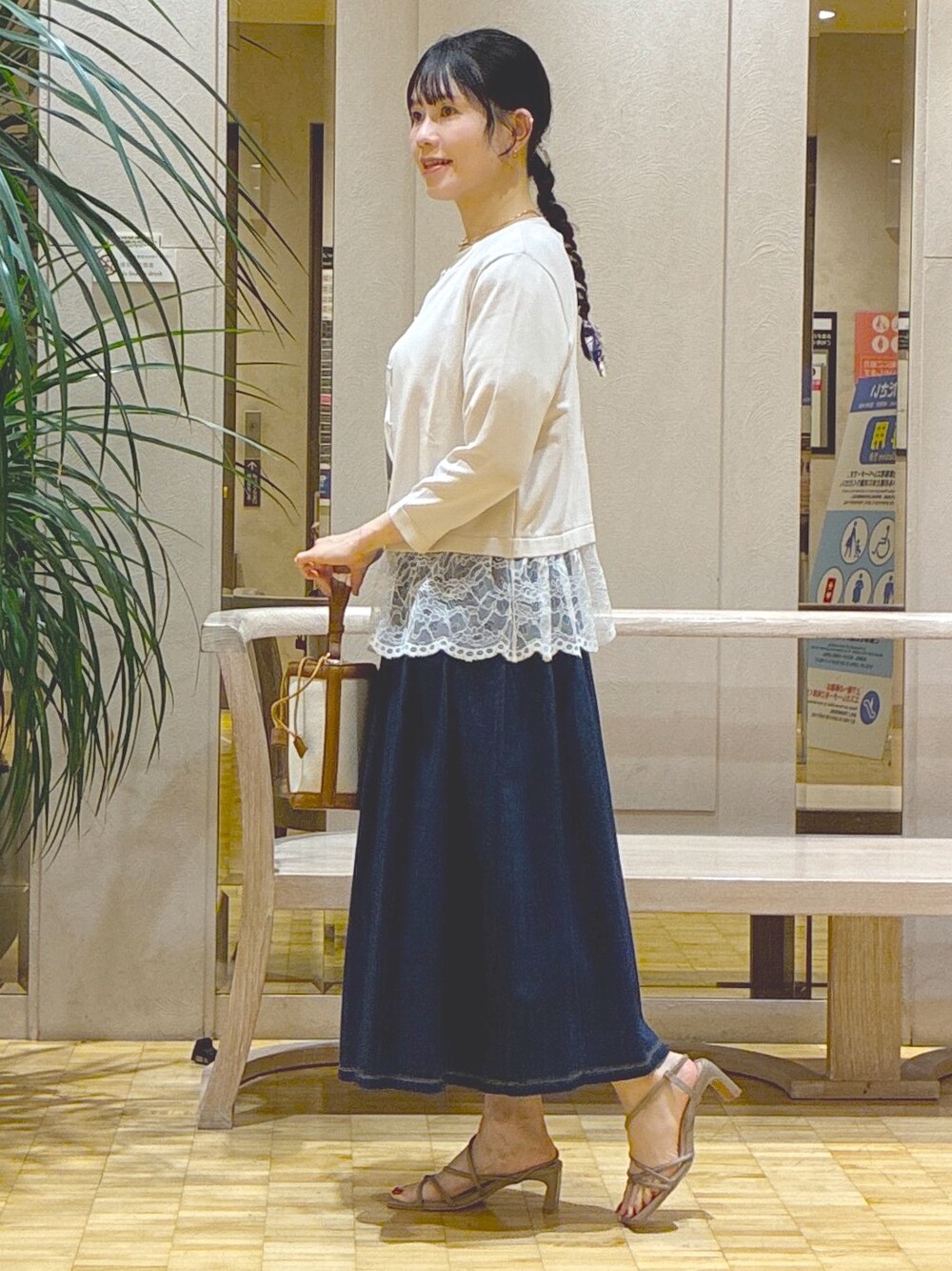 グレー系のカーディガン/ボレロ、ホワイト系のTシャツ/カットソー、ブルー系のデニムスカートを着用したレディースの秋コーディネートの2枚目の写真