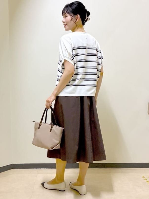 ホワイト系のニット/セーター、グレー系のその他パンツ、ブラウン系のスカートを着用したレディースの夏コーディネートの9枚目の写真