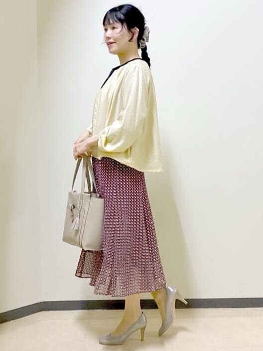 ベージュ系のブルゾン、ブルー系のニット/セーター、レッド系のスカートを着用したレディースの春コーディネートの2枚目の写真