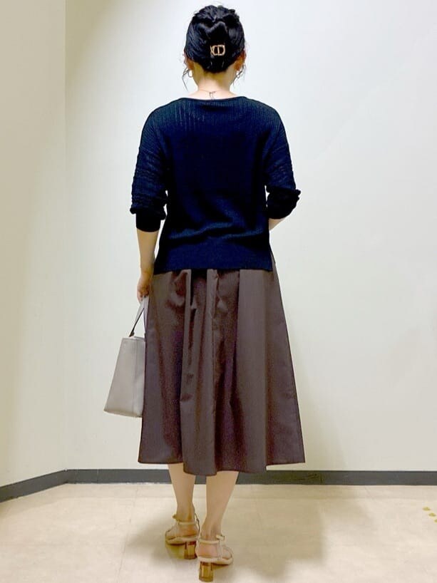 ブラック系のニット/セーター、グレー系のニット/セーター、ブラウン系のスカートを着用したレディースの夏コーディネートの3枚目の写真