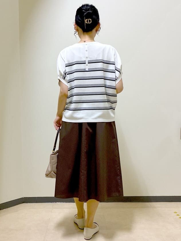 ホワイト系のニット/セーター、ブラウン系のスカート、グレー系のその他パンツを着用したレディースの夏コーディネートの3枚目の写真