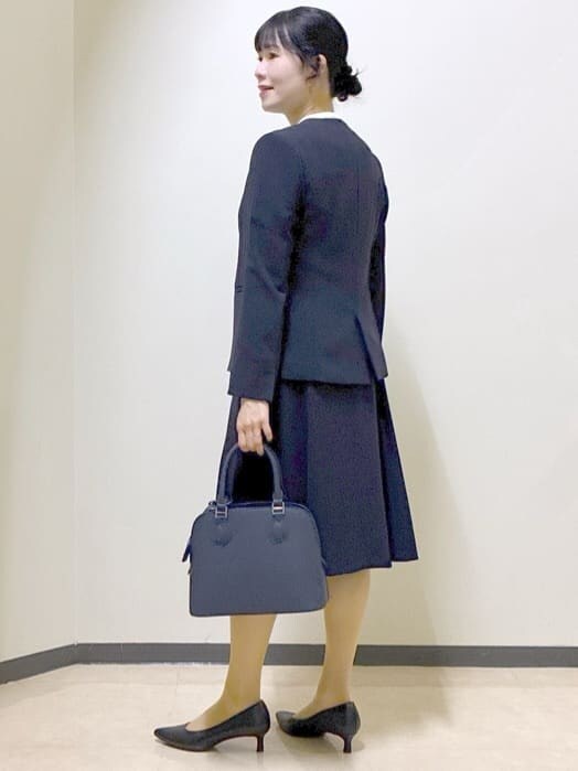 ブルー系のノーカラージャケット、ホワイト系のシャツ/ブラウス、ブルー系のスカートを着用したレディースの冬コーディネートの4枚目の写真