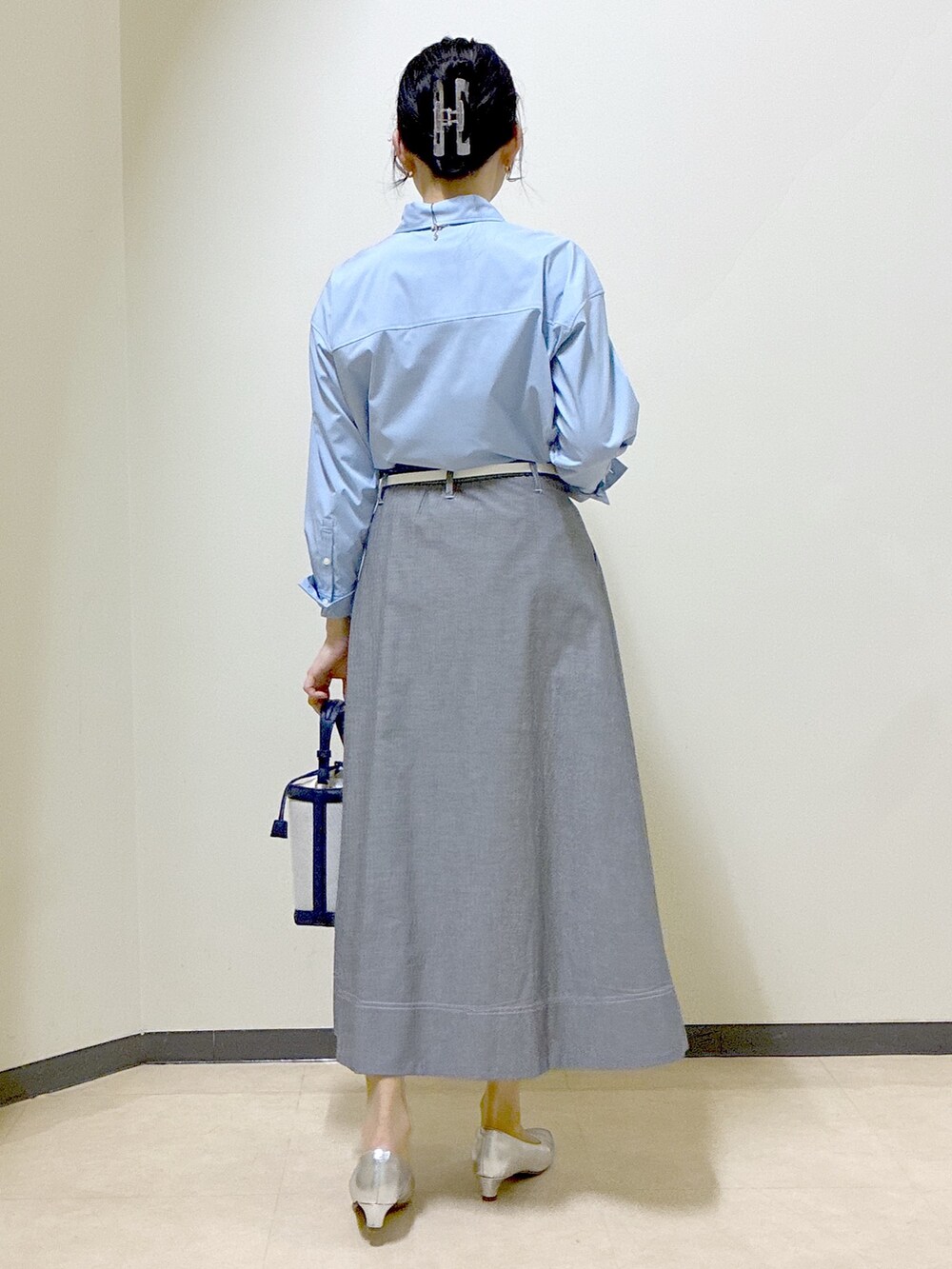 ブルー系のシャツ/ブラウス、ブルー系のニット/セーター、ブラック系のスカートを着用したレディースの春コーディネートの3枚目の写真