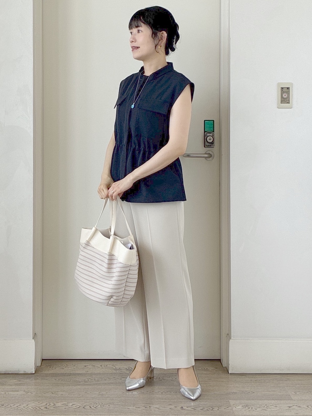 ブルー系のベスト、ベージュ系のその他パンツ、ベージュ系のトートバッグを着用したレディースの春コーディネートの8枚目の写真