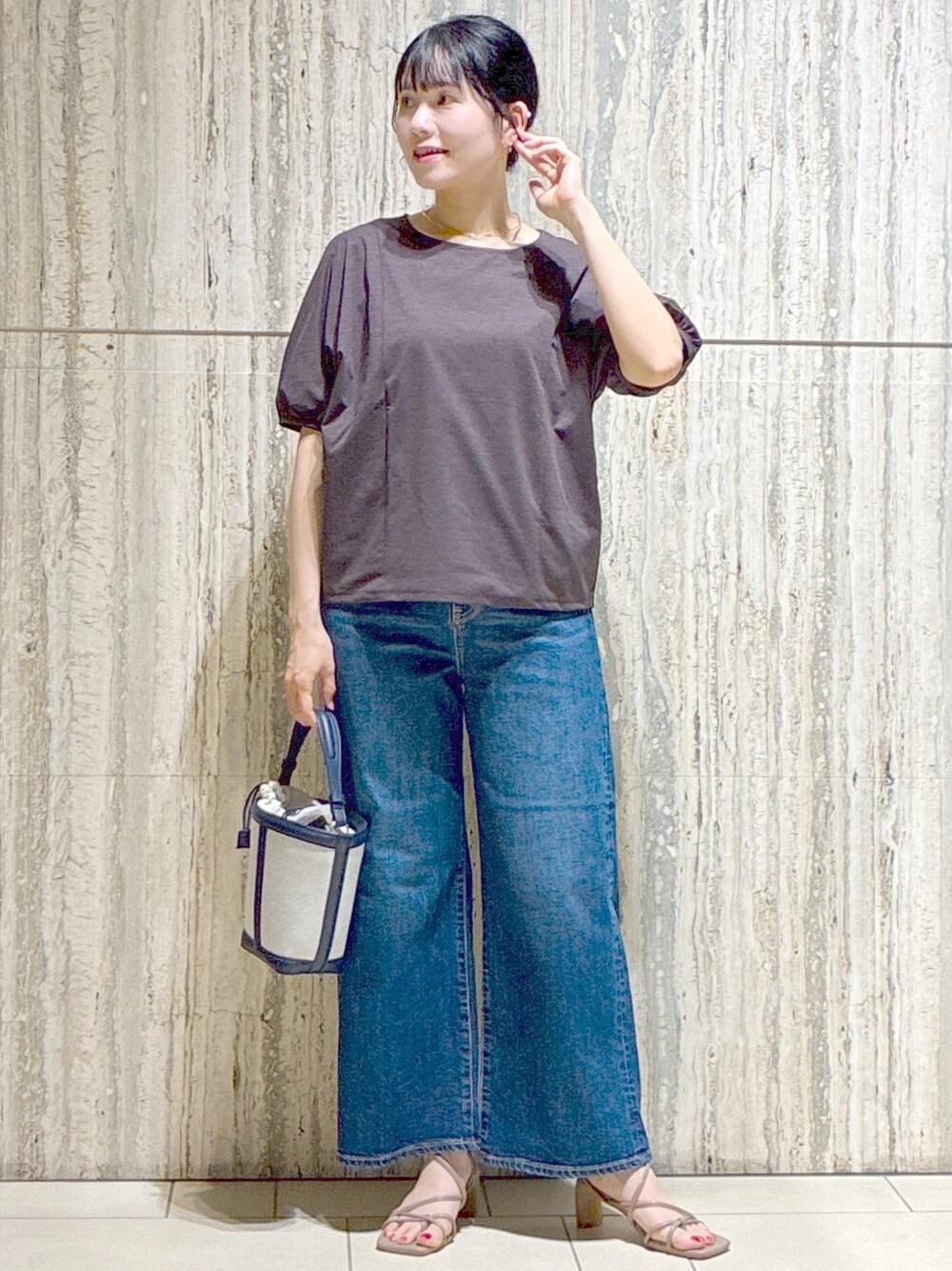 ベージュ系のブルゾン、ブラウン系のTシャツ/カットソー、ブルー系のデニムパンツを着用したレディースの夏コーディネートの9枚目の写真