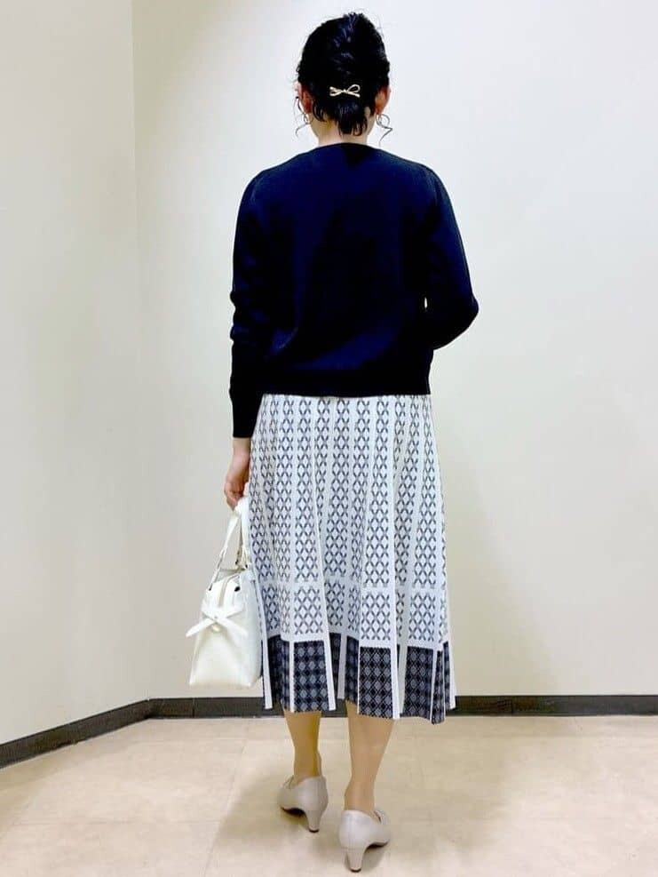 ブルー系のカーディガン/ボレロ、グリーン系のシャツ/ブラウス、ホワイト系のスカートを着用したレディースの春コーディネートの3枚目の写真
