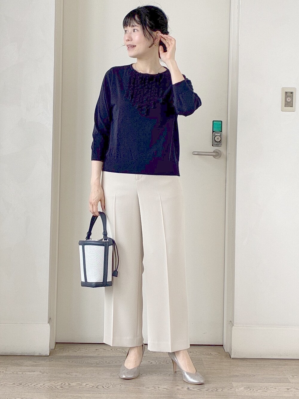 ブルー系のニット/セーター、ベージュ系のその他パンツ、ブルー系のショルダーバッグを着用したレディースの夏コーディネートの6枚目の写真