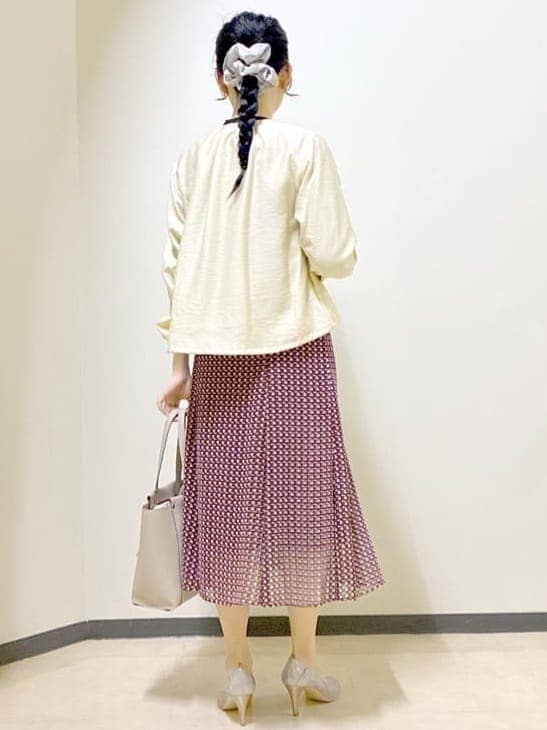 ベージュ系のブルゾン、ブルー系のニット/セーター、レッド系のスカートを着用したレディースの春コーディネートの3枚目の写真