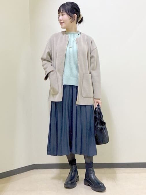 ベージュ系のノーカラーコート、グリーン系のニット/セーター、ブルー系のその他パンツを着用したレディースの冬コーディネートの5枚目の写真