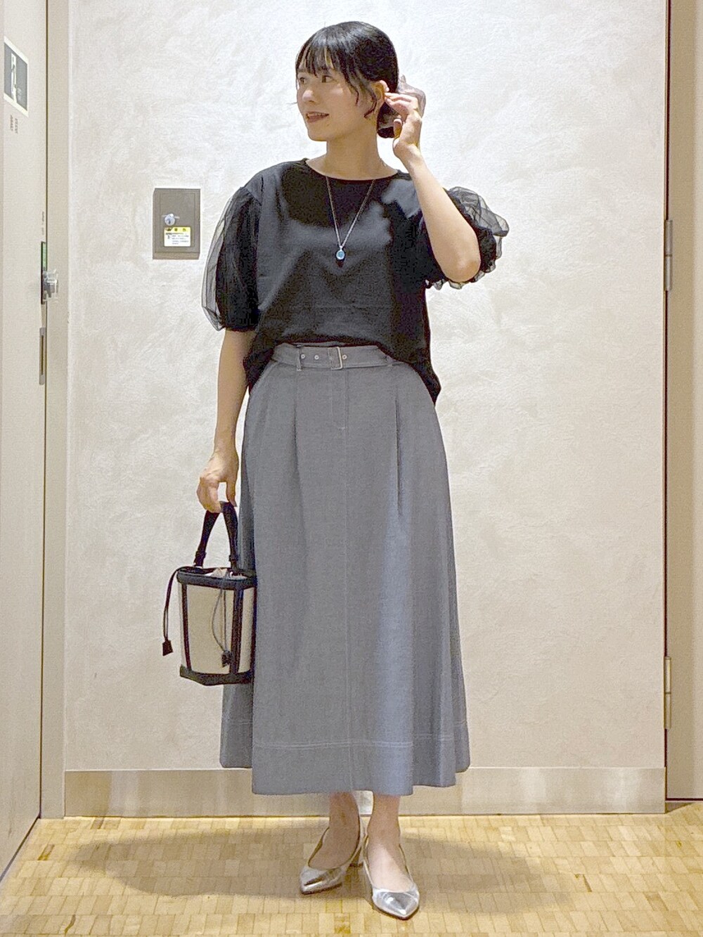 ブラック系のTシャツ/カットソー、ブルー系のスカート、ブルー系のショルダーバッグを着用したレディースの夏コーディネートの5枚目の写真