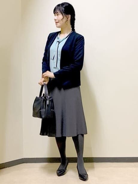 ブルー系のノーカラージャケット、ブルー系のニット/セーター、グレー系のスカートを着用したレディースの秋コーディネートの6枚目の写真