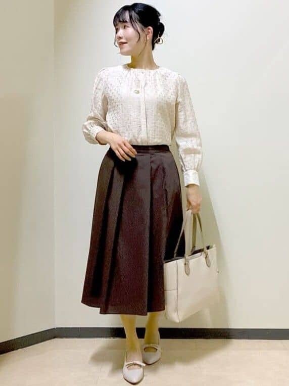 ベージュ系のシャツ/ブラウス、ブラウン系のスカート、ベージュ系のトートバッグを着用したレディースの春コーディネートの6枚目の写真