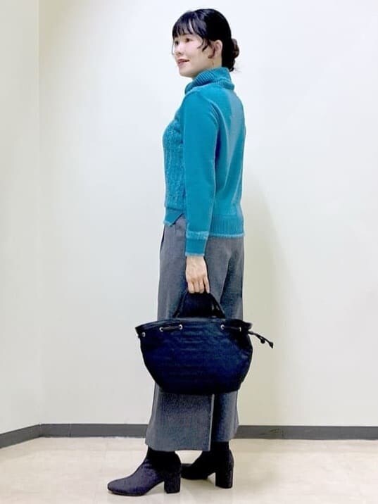 ブルー系のニット/セーター、グレー系のその他パンツ、ブラック系のダウンジャケット/コートを着用したレディースの冬コーディネートの4枚目の写真