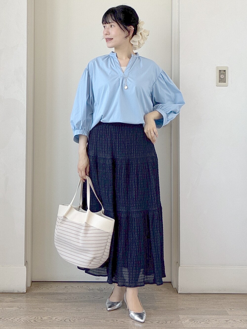 ブルー系のシャツ/ブラウス、ベージュ系のトートバッグ、ベージュ系のタンクトップを着用したレディースの春コーディネートの9枚目の写真