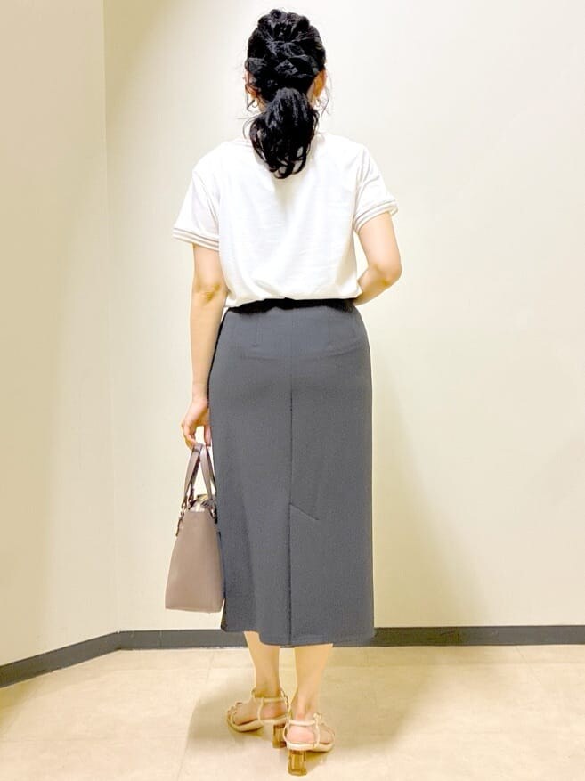 ホワイト系のTシャツ/カットソー、レッド系のカーディガン/ボレロ、グレー系のスカートを着用したレディースの秋コーディネートの3枚目の写真