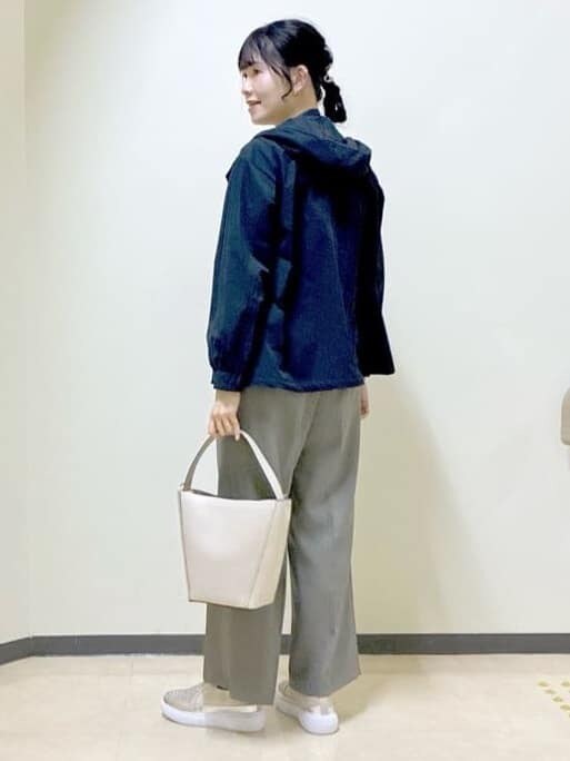 ブルー系のブルゾン、オレンジ系のニット/セーター、ベージュ系のその他パンツを着用したレディースの春コーディネートの4枚目の写真