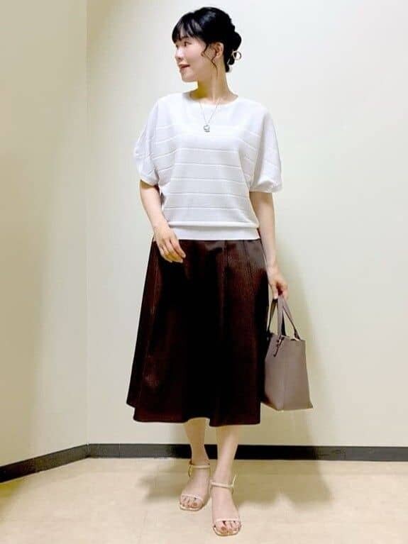 グレー系のニット/セーター、ブラウン系のスカート、ブラック系のニット/セーターを着用したレディースの夏コーディネートの5枚目の写真