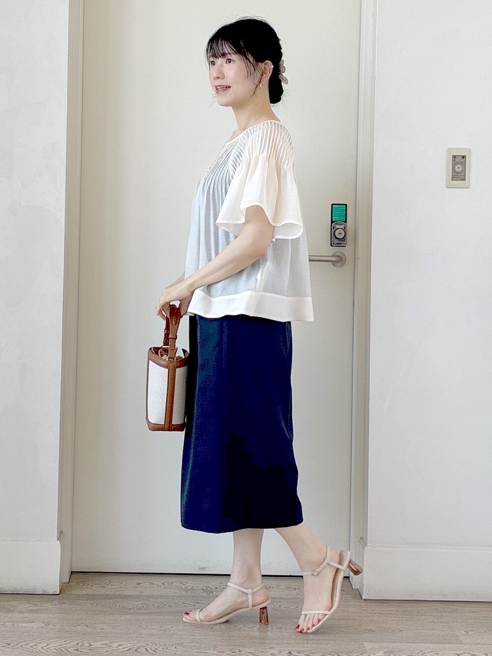 ホワイト系のシャツ/ブラウス、ブラック系のタンクトップ、ブラウン系のベストを着用したレディースの夏コーディネートの2枚目の写真