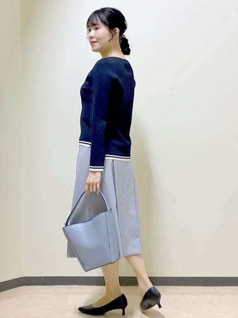 ブルー系のニット/セーター、グレー系のその他パンツ、ブルー系のショルダーバッグを着用したレディースの春コーディネートの4枚目の写真