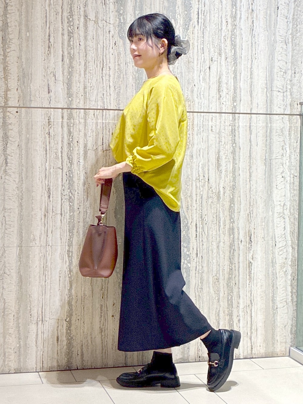 イエロー系のシャツ/ブラウス、ブルー系のその他パンツ、ブラウン系のトートバッグを着用したレディースの秋コーディネートの2枚目の写真