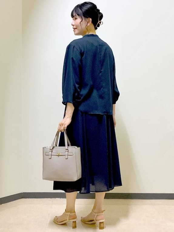 ブルー系のシャツ/ブラウス、ブルー系のスカート、ベージュ系のニット/セーターを着用したレディースの夏コーディネートの4枚目の写真