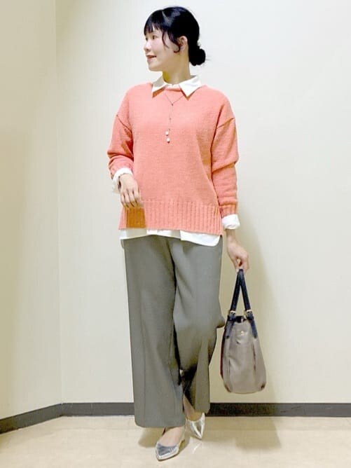 オレンジ系のニット/セーター、ホワイト系のシャツ/ブラウス、ベージュ系のその他パンツを着用したレディースの春コーディネートの5枚目の写真