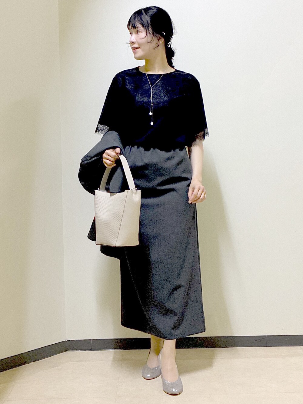 ベージュ系のショルダーバッグ、ベージュ系のワンピース、ブラック系のTシャツ/カットソーを着用したレディースの春コーディネートの5枚目の写真