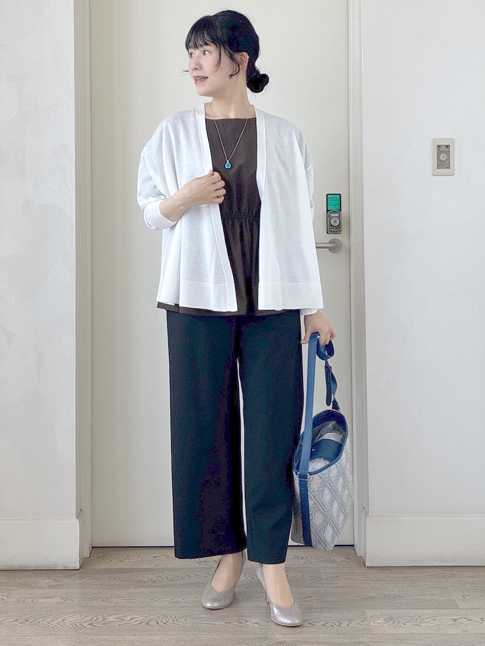 ブラック系のその他パンツ、ブルー系のショルダーバッグ、ホワイト系のカーディガン/ボレロを着用したレディースの春コーディネートの7枚目の写真