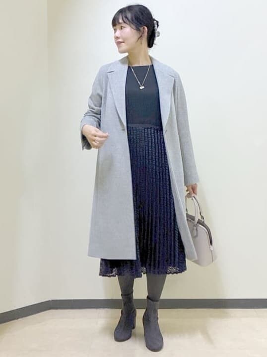 ブルー系のワンピース、グレー系のチェスターコート、ベージュ系のハンドバッグを着用したレディースの冬コーディネートの8枚目の写真