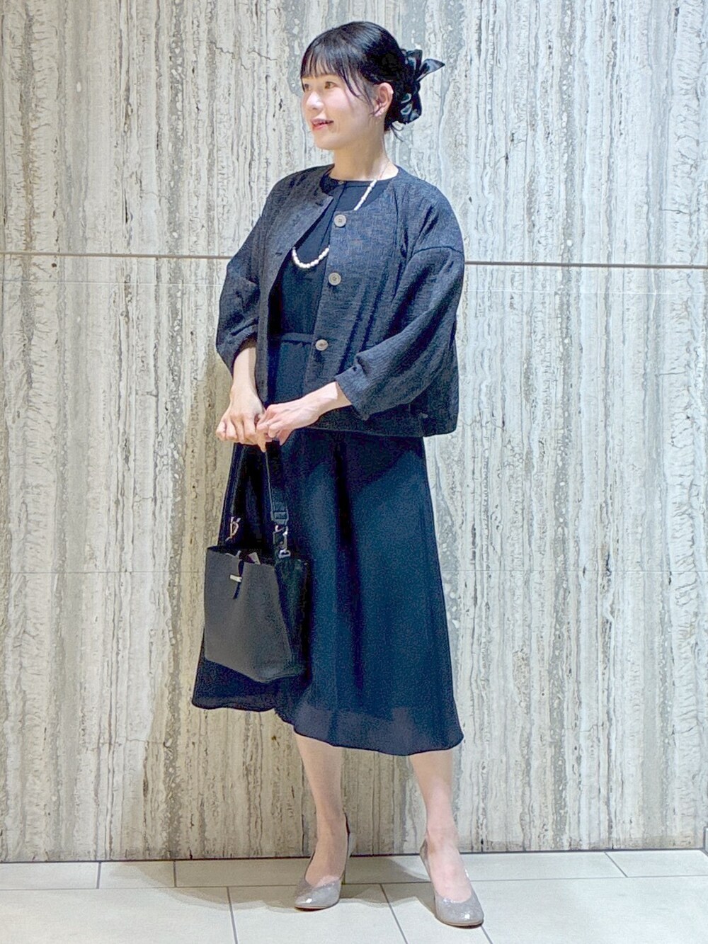 ブルー系のノーカラージャケット、ブルー系のワンピース、ブラック系のトートバッグを着用したレディースの夏コーディネートの8枚目の写真