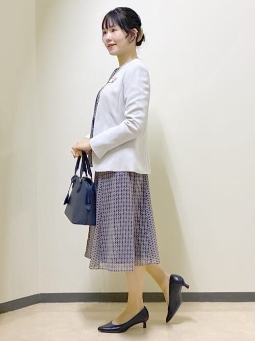 グレー系のノーカラージャケット、ブルー系のシャツ/ブラウス、ブルー系のスカートを着用したレディースの冬コーディネートの2枚目の写真