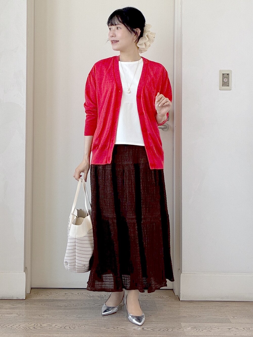 ベージュ系のトートバッグ、ホワイト系のTシャツ/カットソー、オレンジ系のカーディガン/ボレロを着用したレディースの春コーディネートの8枚目の写真
