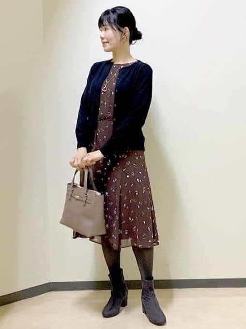 ブラウン系のワンピース、ブラック系のカーディガン/ボレロ、ブラウン系のハンドバッグを着用したレディースの冬コーディネートの6枚目の写真