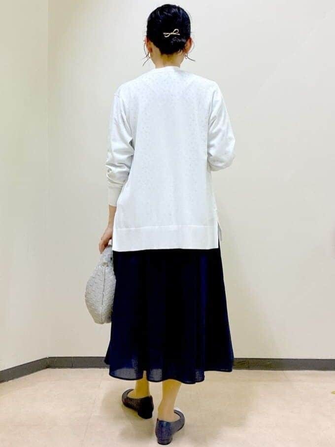 ホワイト系のカーディガン/ボレロ、ブルー系のスカート、ベージュ系のハンドバッグを着用したレディースの春コーディネートの3枚目の写真
