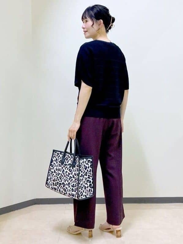 ブラック系のニット/セーター、ブラウン系のその他パンツ、ブラック系のトートバッグを着用したレディースの夏コーディネートの4枚目の写真